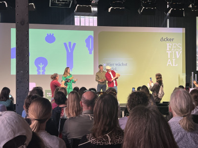 Menschen stehen vor einer Menge auf dem Podium