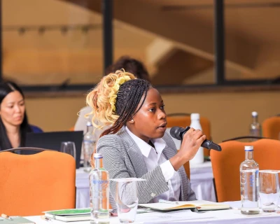 Laura Muwanguzi spricht an einem Mikrofon