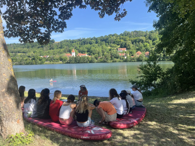 Eine Gruppe Personen sitzt am Ufer