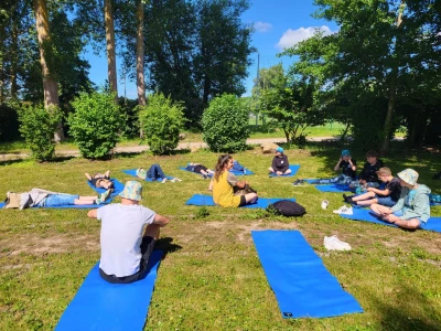 Eine Gruppe Menschen sitzt auf Fitnessmatten
