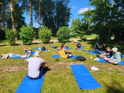 Eine Gruppe Menschen sitzt auf Fitnessmatten