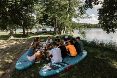 Teilnehmer sitzen auf Stand Up Paddle Boards an Land