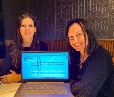 Zwei Personen vor einem Laptop, die Datenbank ist sichtbar