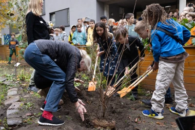 Jane Goodall pflanz gemeinsam mit Kindern einen Baum