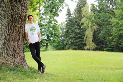 Ein junger Mann lehnt an einem Baum