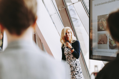 Eine Rednerin referiert vor Publikum